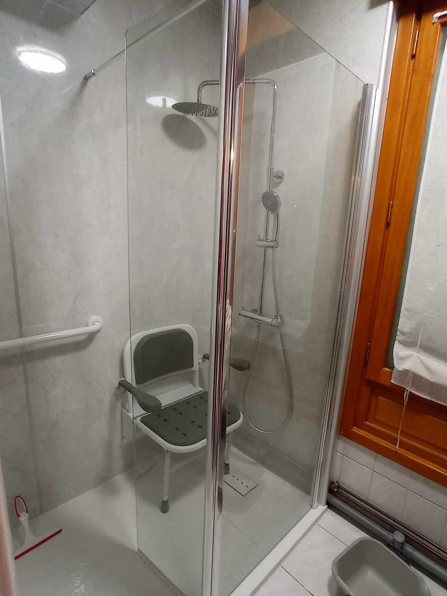 Une petite douche adaptée avec un siège rabattable