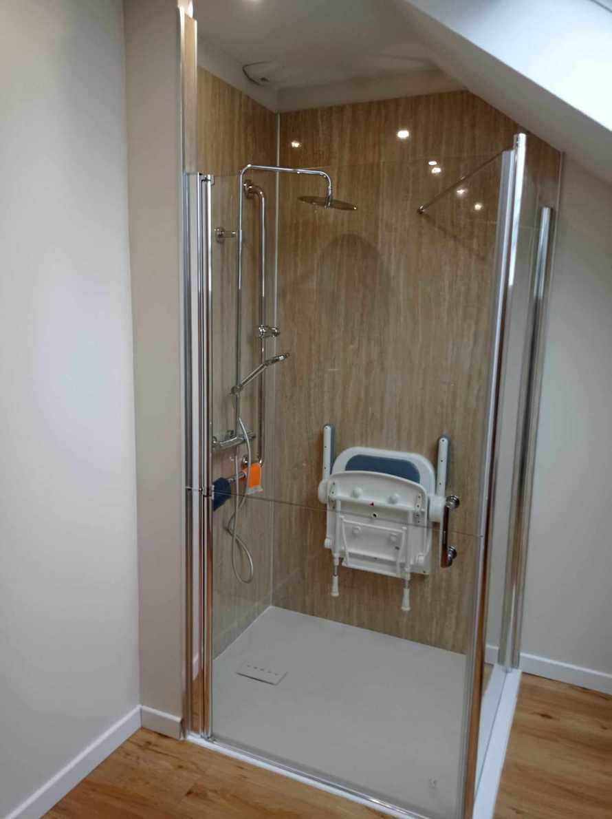 Une douche adaptée avec un siège rabattable en position relevée