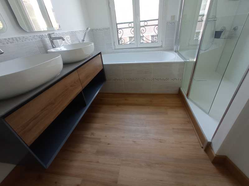 Une salle de bains après la rénovation avec douche accessible, baignoire et meuble vasque