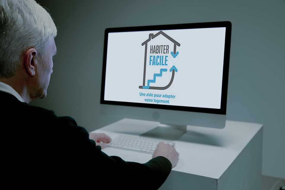 Une personne âgée faisant des recherches sur internet au sujet des aides et subventions possibles pour l'installation d'une douche à l'italienne